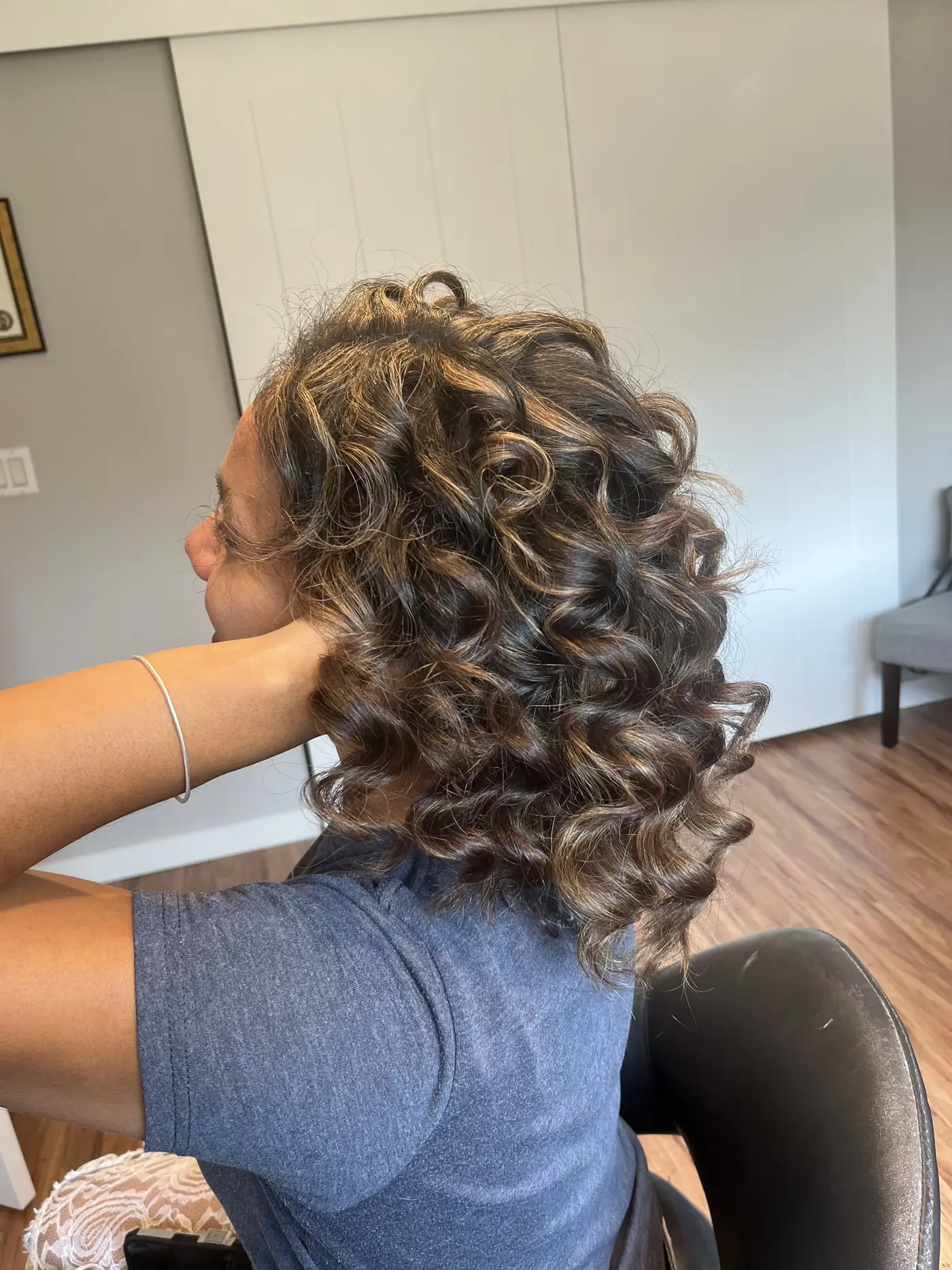 Side view of shoulder-length curly hair with ammonia-free highlights