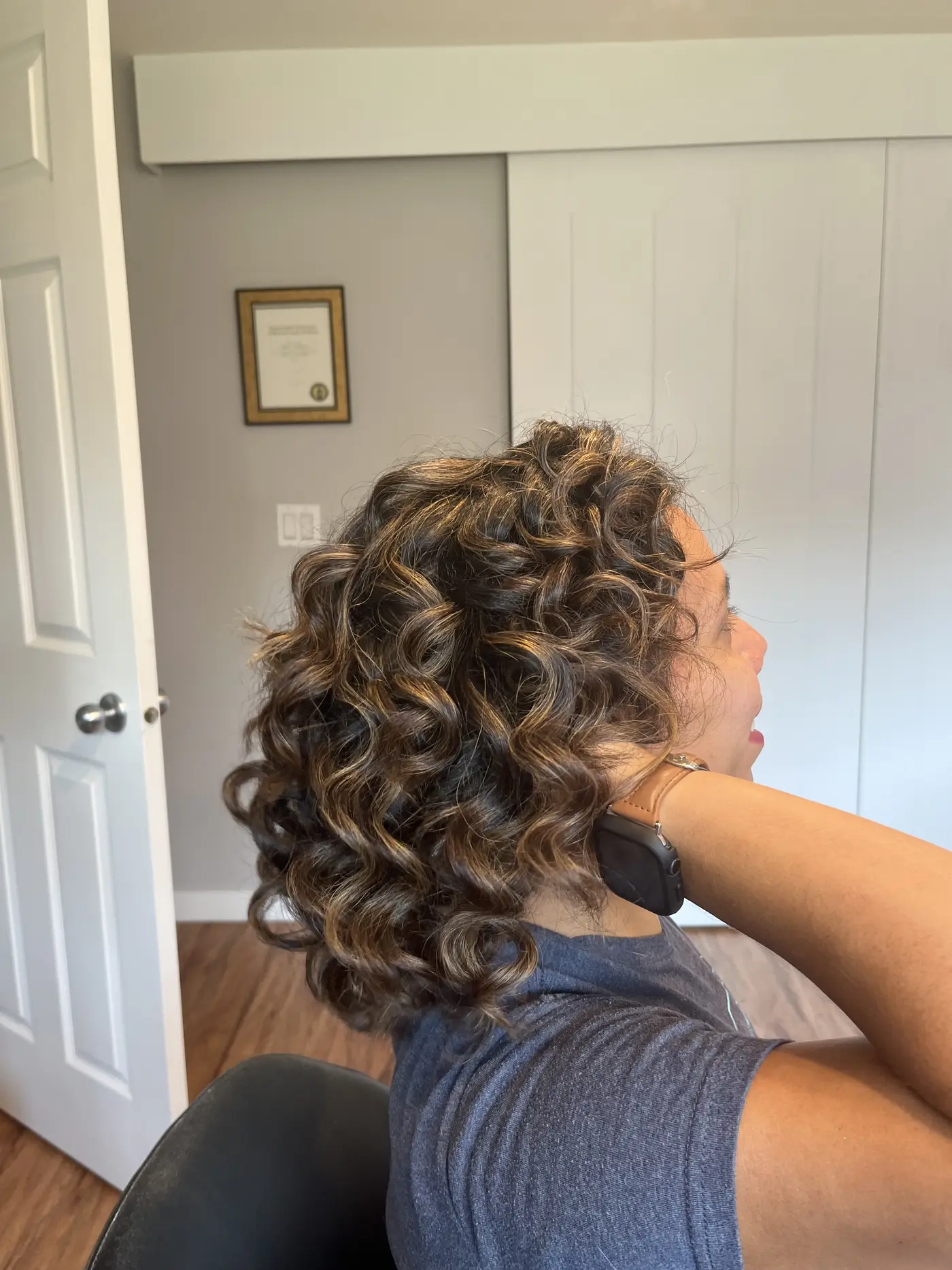 Angled view of curly, highlighted hair with a soft, natural finish