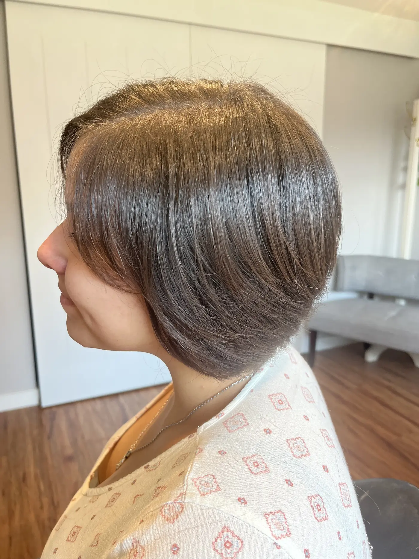 Profile of a short bob haircut tucked behind the ear with a smooth blow-dry