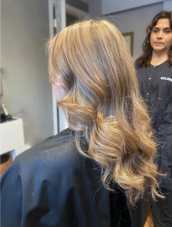 Hair stylist applying foil highlights to a client's hair